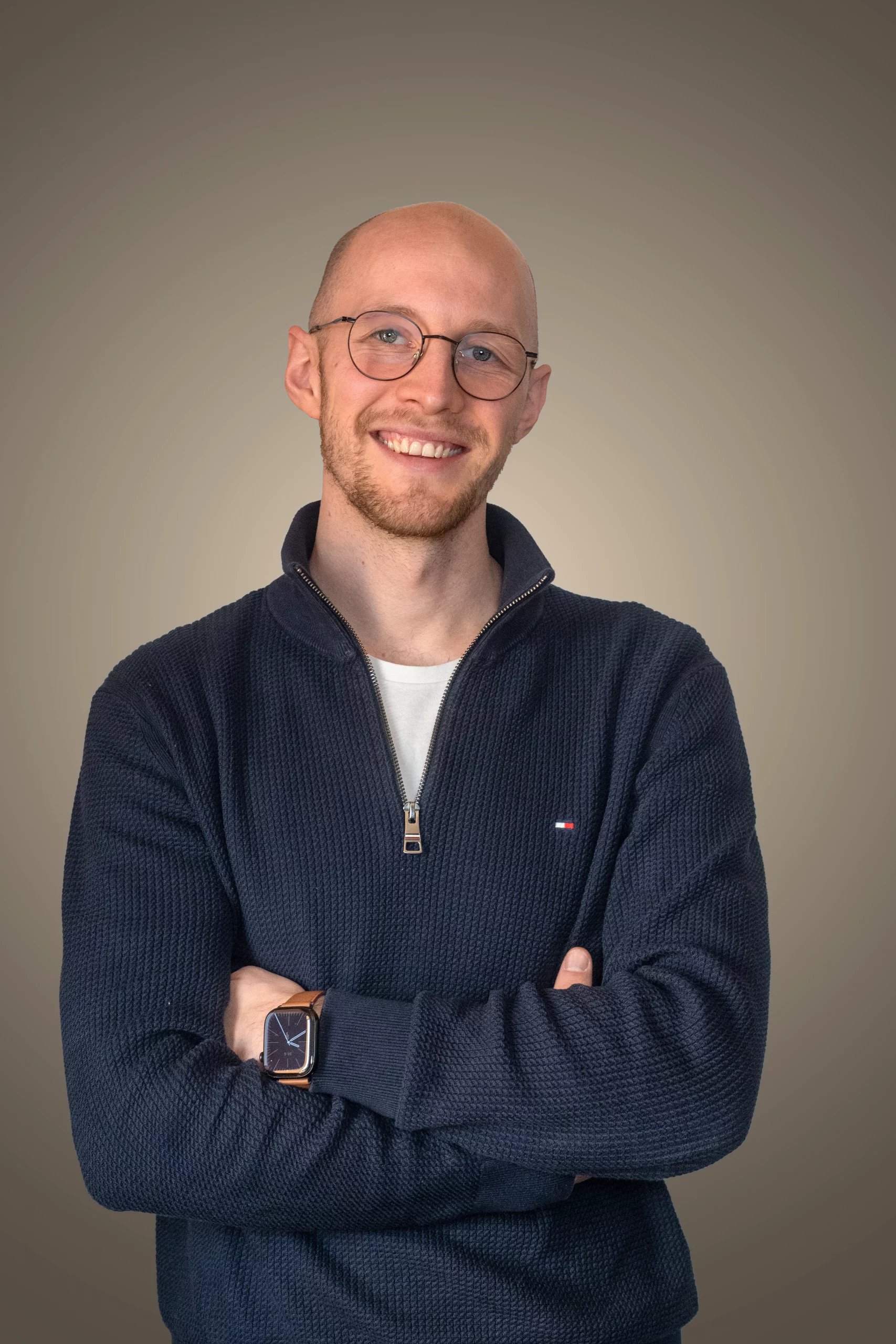 Sven Sickmann mit verschränkten Armen, neutraler Hintergrund.